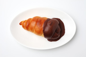 お皿にのせた チョココルネ 菓子パン 白背景