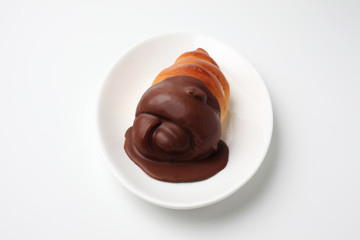 お皿にのせた チョココルネ 菓子パン 白背景