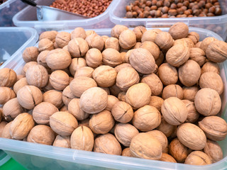 Lots of walnuts in a plastic box at the grocery store.