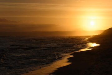 Fototapeta na wymiar Golden Sky Sunset Shimmering On The Beach