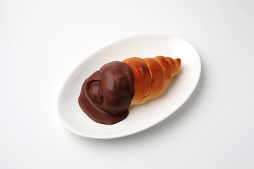 お皿にのせた チョココルネ 菓子パン 白背景