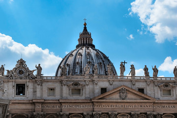Michelangelo's dome on St. Peter's Basilica and the statues of Christian saints. Rome, Italy.
