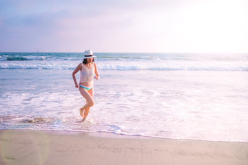young woman on sunset beach and joyful running . happy summer vacation. positive lifestyle and relaxing travel. nature recreation.