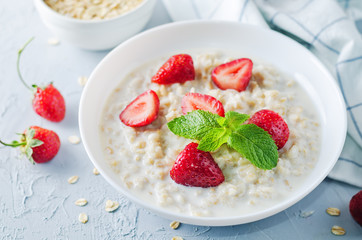 Oatmeal porridge with fresh strawberries and raspberries