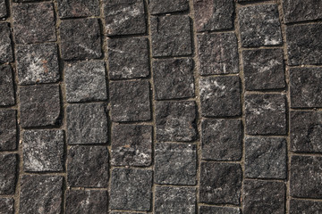 Abstract background of gray cobblestone pavement,close-up, top view.