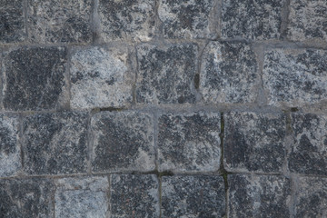 Abstract background of gray cobblestone pavement,close-up, top view.