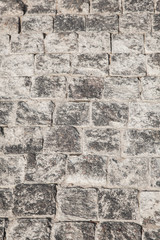 Abstract background of gray cobblestone pavement,close-up, top view.