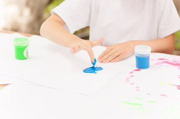 Obraz na płótnie Canvas the child draws with finger paints