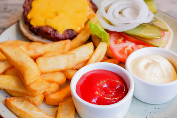 still life with fast food hamburger menu, french fries and ketchup.Junk food. Fast carbohydrates not good for health, heart.Restaurant serving of burger with fries. plate with traditional american