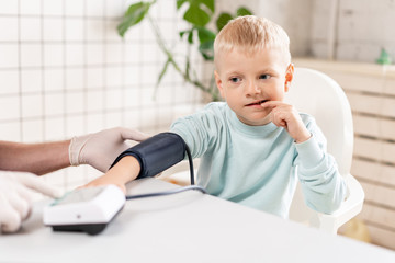 Doctor measuring blood pressure of a little boy. Diagnostic, healthcare, medical service. Doctor pediatrician concept