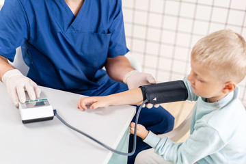 Doctor measuring blood pressure of a little boy. Diagnostic, healthcare, medical service. Doctor pediatrician concept