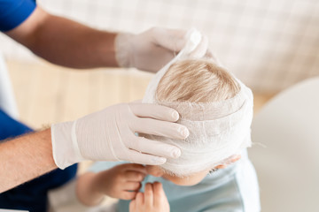 Doctor bandaged a boy head with trauma in his head and elastic bandaged around his head