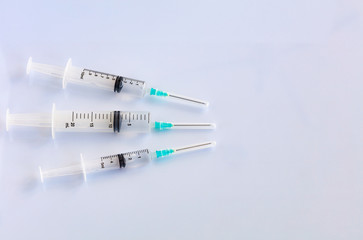 Several different syringes on a white smooth table are filled with mortar and ready for use.