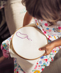 little girl embroider needlework .