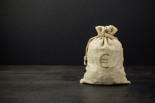 A full bag of dollars on a dark table