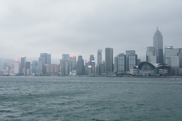 Naklejka premium 08 03 2019 China, Hong Kong, Victoria Harbour - skyscrapers in a cloudy day