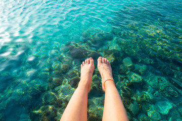 Ibiza girl legs at Portinatx beach clear water