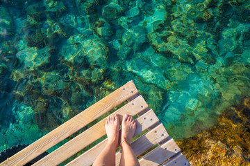 Ibiza girl legs at Portinatx beach clear water