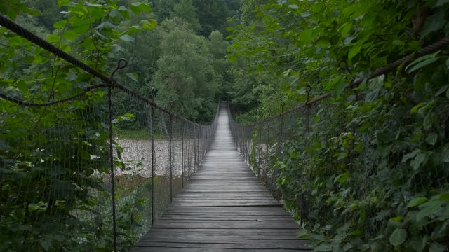 Fragile wooden bridge over mountain river, courage to move on the other side