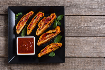 Pizza roll stromboli with cheese salami olives and tomatoes