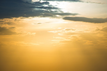 Sunset orange sky with sun and clouds in beige color