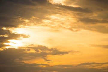 Sunset orange sky with sun and clouds in beige color