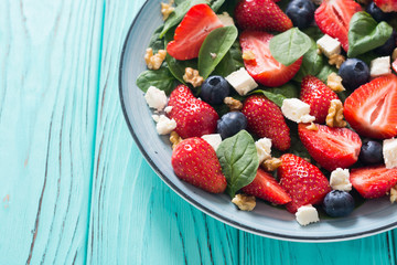 Summer Strawberry salad with spinach , cheese , nuts and blueberry