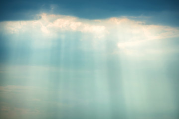 Sunset view of dramatic storm sky with dark clouds and bright sunbeams shining through them. Can be used as nature background