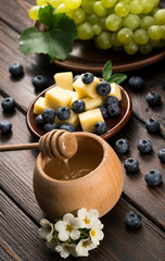 Tasting dish of cheese, blueberry and honey on a wooden background