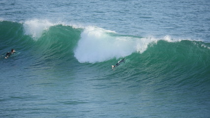 Beach with waves crashing at the ocean with surfer shot in high resolution 4k resolution