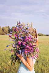 The girl covered her face with a huge bright bouquet