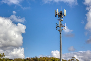 Cellular, mobile phone transmitter tower with blue sky and clouds 1