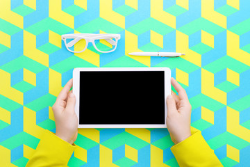 Man holds a tablet and looks at the screen. Mobile development. Innovational online businesses. Internet technologies. Trendy design. Geometry. Fashionable vibrant colors. Using a device. UX and UI.