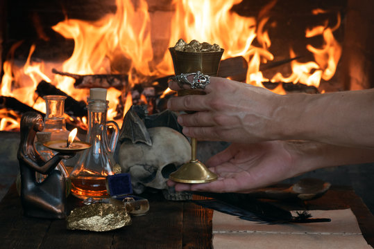 Alchemist is working at his magic table and producing a gold.