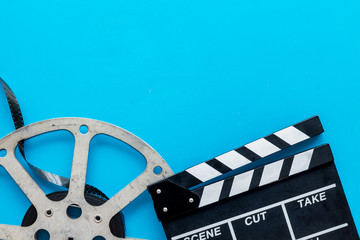 Watch film in cinema with video tape and clapperboard on blue background top view