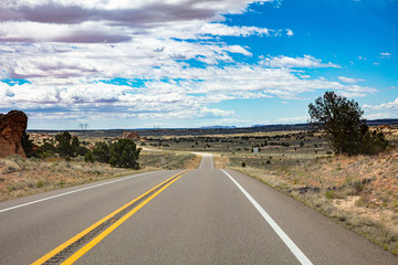 Fototapeta na wymiar Long highway in the american countryside, blue sky