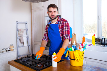 Man makes cleaning the kitchen. Young man washes an oven. Cleaning concept.