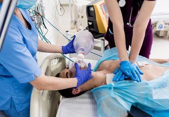 Doctors give resuscitation to a male patient in the emergency room. Cardiac massage