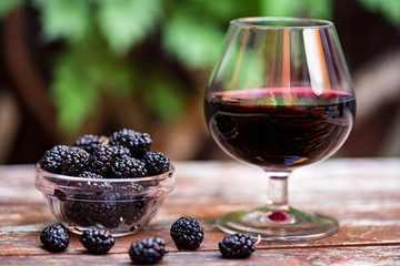 Close up fresh mulberries fruit in bowl and wine in glass