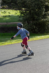 Young boy rollerblading near his home