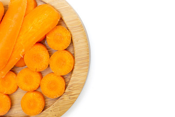 Lot of pieces of peeled orange baby cut carrot copyspace on right on bamboo plate flatlay isolated on white background