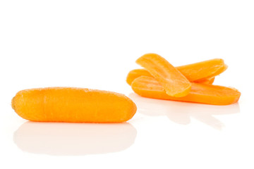 One whole lot of slices of peeled orange baby cut carrot focus on a whole carrot isolated on white background
