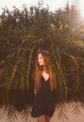 Naklejka premium Portrait of young woman among branches of tree