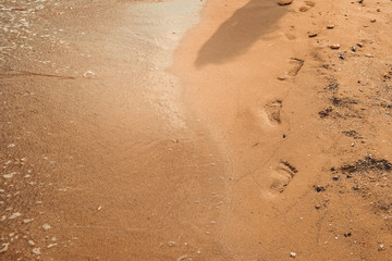 close up of footprint on golden sand beach 
