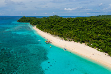 Aerial view of a beautiful sandy beach surrounded by tropical foliage (Pukka Shell Beach, Boracay, Philippines)