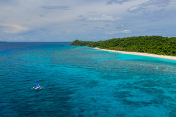 Aerial view of a beautiful sandy beach surrounded by tropical foliage (Pukka Shell Beach, Boracay,...