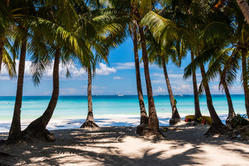 A beautiful tropical sandy beach surrounded by palm trees and warm ocean (White Beach, Boracay)