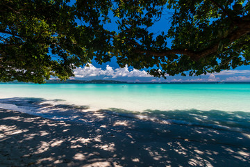 A beautiful tropical sandy beach surrounded by palm trees and warm ocean (White Beach, Boracay)
