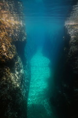 Fototapeta na wymiar Crevice between large rocks underwater, Mediterranean sea, Spain, Costa Brava, Aigua Xelida, Palafrugell, Catalonia