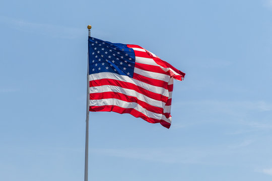 American Flag waving on pole, with bright vibrant red white and blue colors